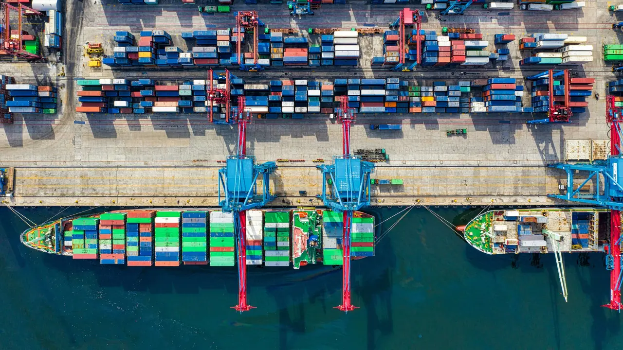 Aufsicht auf ein beladenes Containerschiff im Hafen
