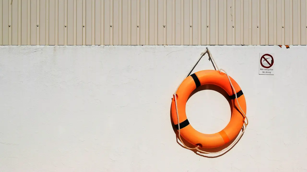 Orangener Rettungsring vor beiger Wand